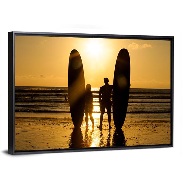 Surfer Couple Holding Long Surf Boards At Sunset On Beach Canvas Wall Art-3 Horizontal-Gallery Wrap-25" x 16"-Tiaracle