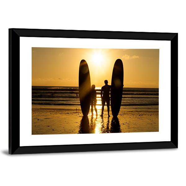 Surfer Couple Holding Long Surf Boards At Sunset On Beach Canvas Wall Art-3 Horizontal-Gallery Wrap-25" x 16"-Tiaracle