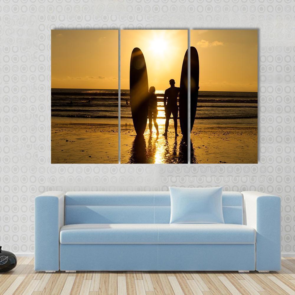 Surfer Couple Holding Long Surf Boards At Sunset On Beach Canvas Wall Art-3 Horizontal-Gallery Wrap-37" x 24"-Tiaracle